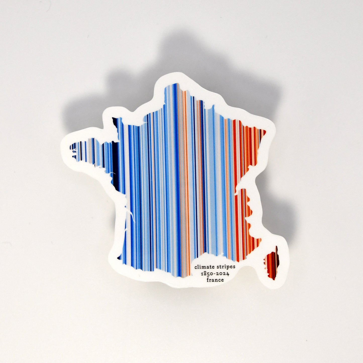 Sticker shaped like a map of France with blue and red stripes on a white background